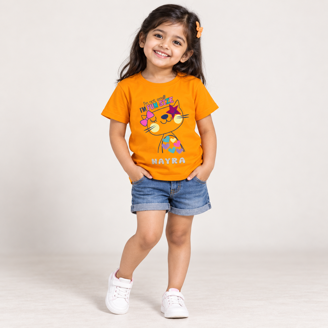 4-year-old Indian girl wearing a personalised baby-pink Fun Size cat T-shirt with the name NAYRA.